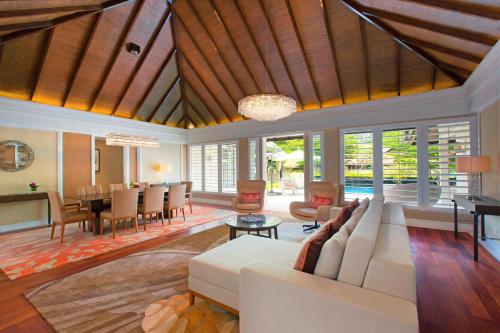 a living room with a white couch and a dining room at The Westin Langkawi Resort & Spa in Kuah
