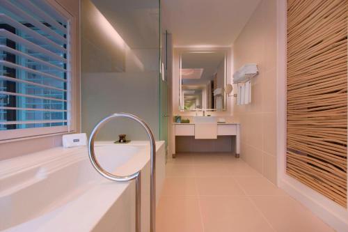 a bathroom with a tub and a sink and a mirror at The Westin Langkawi Resort & Spa in Kuah