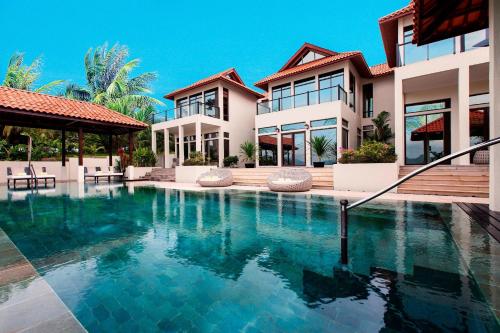 a house with a swimming pool in front of it at The Westin Langkawi Resort & Spa in Kuah