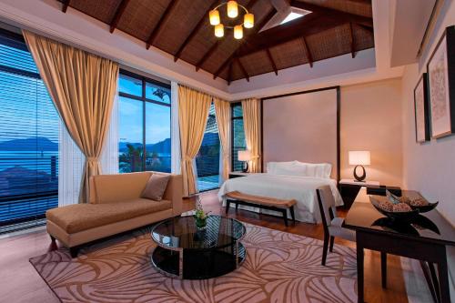 a bedroom with a bed and a couch and a table at The Westin Langkawi Resort & Spa in Kuah
