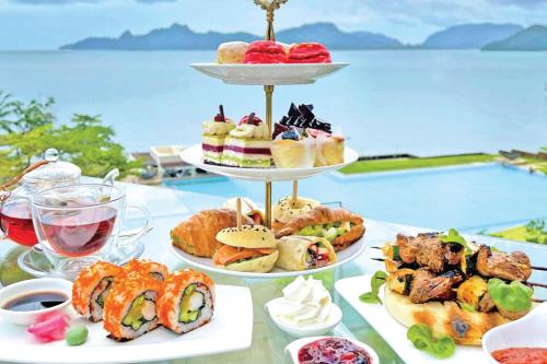 a table with three tiers of sandwiches and pastries at The Westin Langkawi Resort & Spa in Kuah