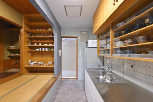 eine Küche mit einer Spüle und einem Kühlschrank in der Unterkunft 島の風景に溶け込む、日本の伝統旅館「かんなから」 in Tonosho