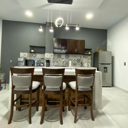 a kitchen with a dining room table and chairs at Depas Mololoa in Tepic