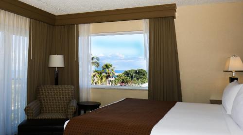 Holiday Inn Express- North Palm Beach and IHG Hotel في جونو بيتش: غرفه فندقيه بسرير ونافذه