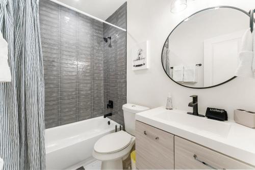 a bathroom with a sink and a toilet and a mirror at Peaceful & Modern Historic Norcross Home in Norcross