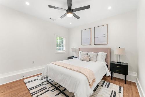 a white bedroom with a bed and a ceiling fan at Peaceful & Modern Historic Norcross Home in Norcross