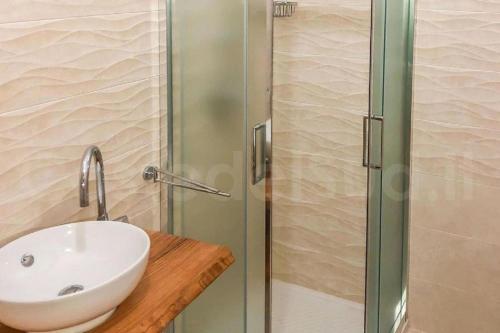 La salle de bains est pourvue d'un lavabo et d'une douche en verre. dans l'établissement Villa Rosa zona Torre San Giovanni, à Torre San Giovanni