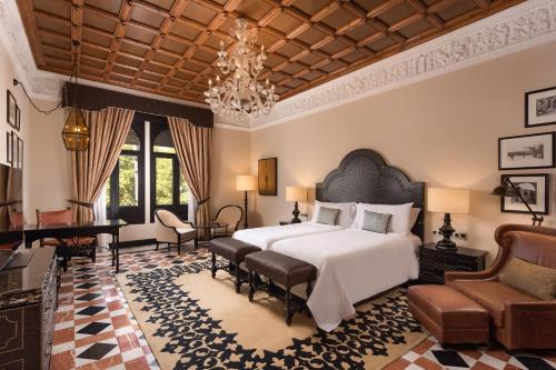 Un dormitorio con una cama grande y una lámpara de araña. en Hotel Alfonso XIII, a Luxury Collection Hotel, Seville, en Sevilla