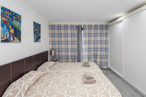 ein Schlafzimmer mit einem großen Bett mit Schuhen drauf in der Unterkunft Lightbooking Sun Club Playa Ingles 2 habitaciones in Maspalomas