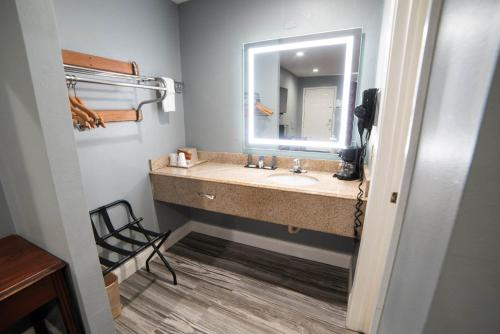 een badkamer met een wastafel en een spiegel bij Americas Best Value Inn and Suites Siloam Springs in Siloam Springs
