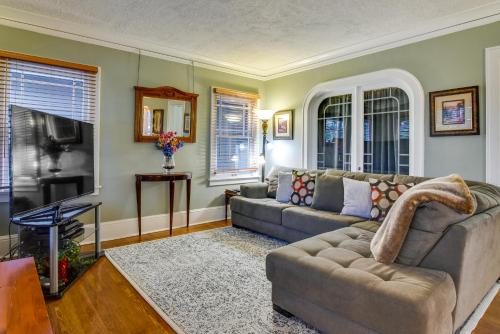 a living room with a couch and a television at Walk to Williams District Home with Hot Tub and Patio in Portland
