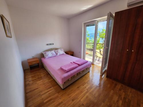 a bedroom with a bed with a pink blanket at Sunrise Apartments Baošići in Herceg-Novi