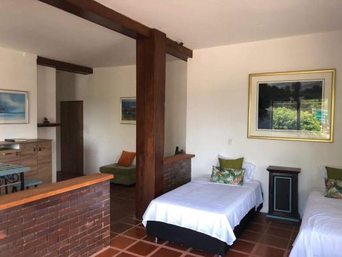 a bedroom with two beds and a chair in a room at La Casona Llanera in San Martín