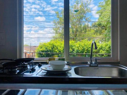 a kitchen counter with a sink and a window at La Casona Llanera in San Martín