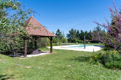 un gazebo à côté d'une piscine dans l'établissement La Fermette du Pérougord à Rouffignac-St-Cernin Périgord Noir, à Rouffignac-Saint-Cernin-de-Reilhac