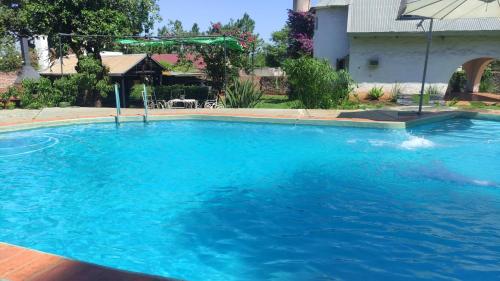 a large pool with blue water in a yard at " Casa quinta "San Bernardo" Con Pileta y amplio jardín in Posadas