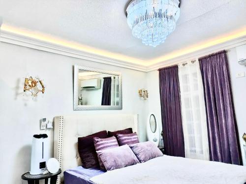 1 dormitorio con cama, espejo y lámpara de araña en La Maison De Rouch - Lancaster en General Trias