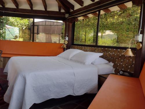 a bedroom with a white bed and a window at Glamping Cottage Master Room en Guatapé-Desayuno in Chiquinquirá