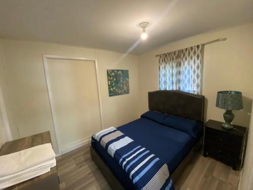 a bedroom with a blue bed and a window at The Water Street Inn in Napanee