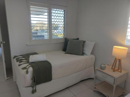 a white couch in a room with a window at Sandy Shores Holiday Units in Caloundra