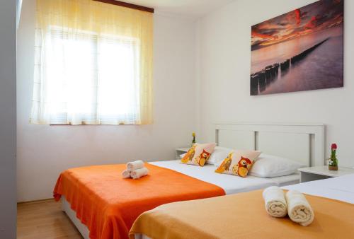 1 Schlafzimmer mit 2 Betten und orangefarbener Bettwäsche in der Unterkunft Secluded fisherman's cottage Cove Virak, Hvar - 17875 in Gdinj