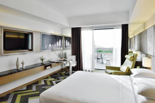 pokój hotelowy z łóżkiem i telewizorem w obiekcie Courtyard by Marriott Agra w mieście Agra
