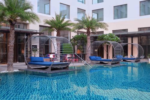阿格拉的住宿－阿格拉萬怡酒店，两把椅子和一个游泳池
