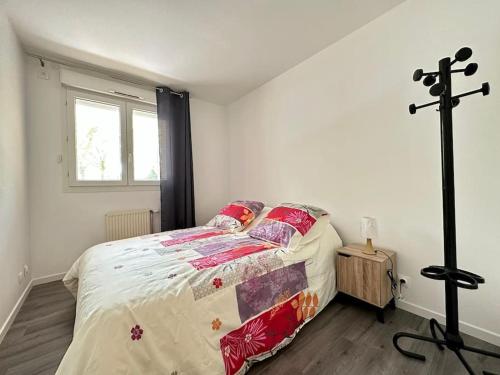 - une chambre avec un lit et une croix sur le mur dans l'établissement Le cosy de Disney Land paris, à Bussy-Saint-Georges