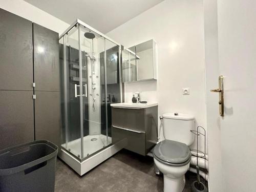 une salle de bain avec toilettes et douche en verre dans l'établissement Le cosy de Disney Land paris, à Bussy-Saint-Georges