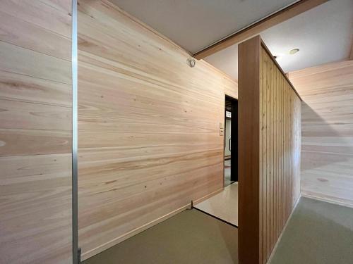 a wooden wall in a room with a hallway at Guest Room Furusatomura Kogeikan in Omachi