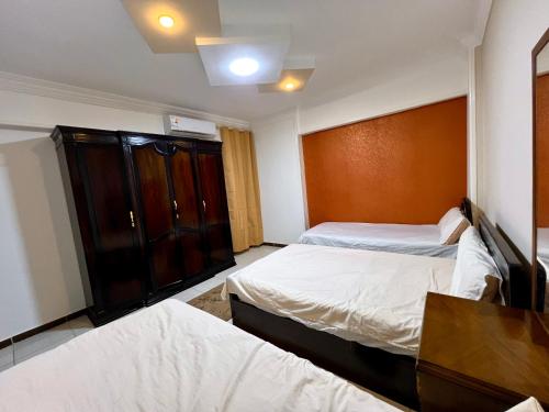 a hotel room with two beds and a cabinet at سى فيو السريا in Alexandria