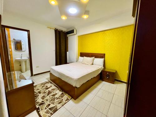 a bedroom with a bed and a yellow wall at سى فيو السريا in Alexandria