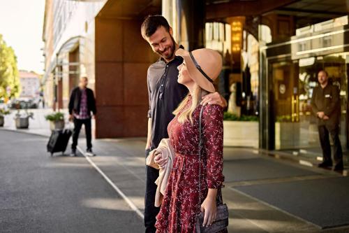 un homme et une femme debout devant un bâtiment dans l'établissement Sheraton Zagreb Hotel, à Zagreb