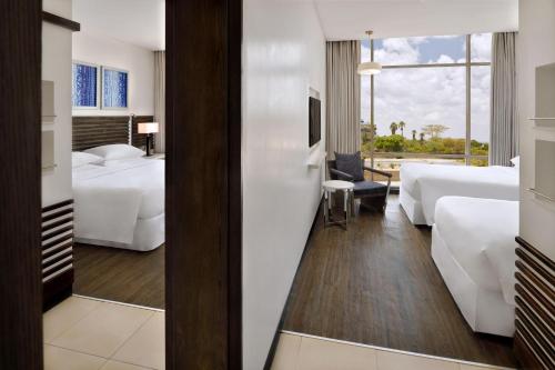a hotel room with two beds and a window at Four Points by Sheraton Nairobi Airport in Nairobi