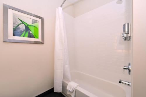 a bathroom with a white tub and a shower at Four Points By Sheraton Mount Prospect O’Hare in Mount Prospect