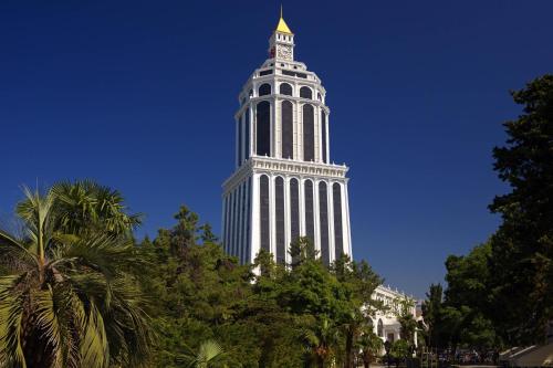 un edificio blanco alto con una torre de reloj en Sheraton Batumi Hotel, en Batumi