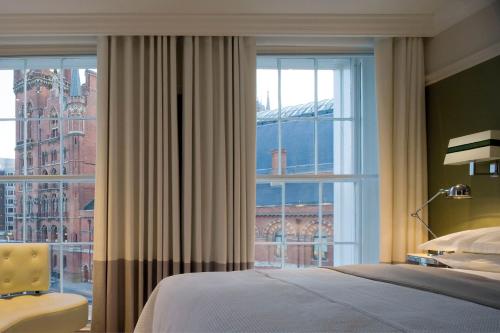 a bedroom with a bed and a large window at Kaya Great Northern Hotel, London in London