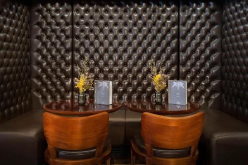 a table and chairs in a room with a leather wall at Kaya Great Northern Hotel, London in London