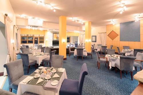 a dining room with tables and chairs and tablesktop at Protea Hotel by Marriott Walvis Bay Pelican Bay in Walvis Bay