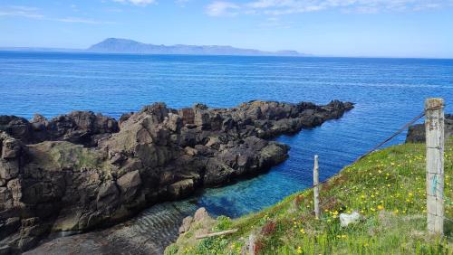 a view of the ocean from a cliff at Happy-Cove Guesthouse - by the sea in Bakkafjörður