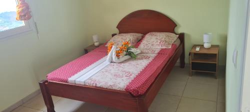 Quartier la Fleury GuinéにあるVILLA LINEDDY/ZINNIAの花が飾られたベッドのある寝室