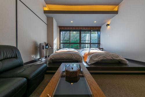 uma sala de estar com duas camas e um sofá em Hakone Kuoritei em Hakone