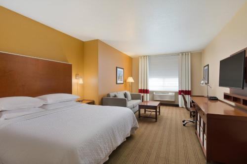 a hotel room with a large bed and a television at Four Points by Sheraton Portland East in Portland