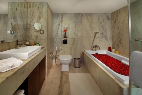 a bathroom with a tub and a toilet and a sink at Four Points by Sheraton Hotel and Serviced Apartments Pune in Pune