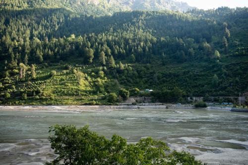 a view of a river with mountains in the background at The Kamru Riverside Camps and Resorts in Sāngla