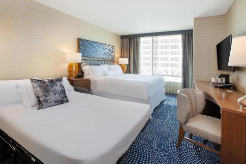 a hotel room with two beds and a desk at The Westin Milwaukee in Milwaukee