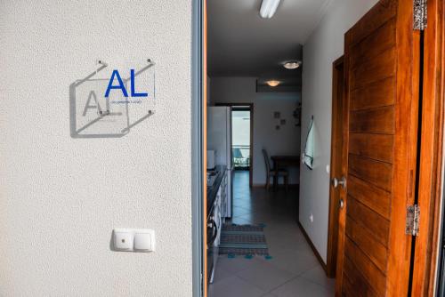 uma porta para um corredor com um sinal de Al na parede em Villas Horizonte Capazi em Porto Santo