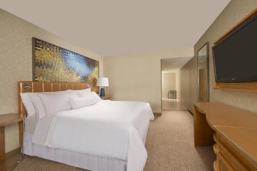 a bedroom with a white bed and a flat screen tv at The Westin Las Vegas Hotel & Spa in Las Vegas