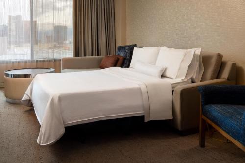 a hotel room with a large white bed and a couch at The Westin Las Vegas Hotel & Spa in Las Vegas