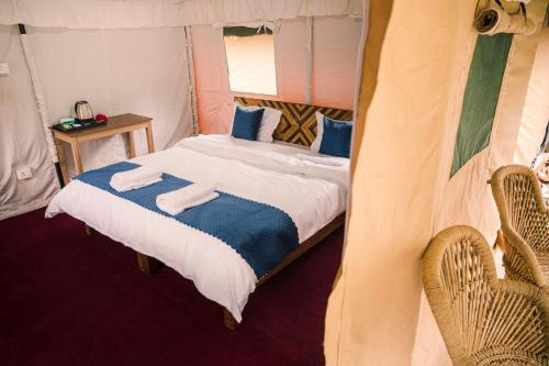 a bedroom with a bed with towels on it at The Kamru Riverside Camps and Resorts in Sāngla